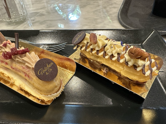 Two fancy mini eclairs in ‘Tortchen & Co’ at Phantasialand. The eclairs are decorated with caramel and pecan nuts, and one with cherry and chocolate. Both were excellent.