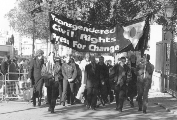 Classic black and white photo of a group of about two dozen trans people walking down Whitehall after delivering a petition to 10 Downing Street. The banner reads: ‘Transgendered Civil Rights. Press for Change’. An account of this event in October 1997 is contained in my book ‘Pressing Matters’ (Vol 1)