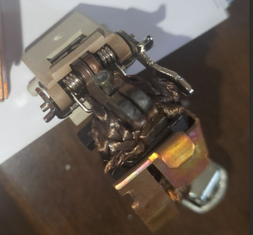 Innards of a DC circuit breaker showing burned and discoloured contacts and metalwork.