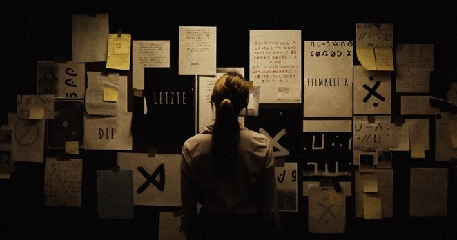 Wand voller Notizen und okkulter Symbole aus dem Film 