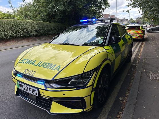 A very clean Kia EV in Ambulance livery of yellow and green. The word ‘Ambulance’ is spelt backwards in capitals on the bonnet so drivers can read it in their rear view mirror.