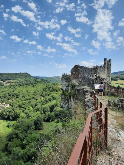 A ruined high castle over a green verdant valley