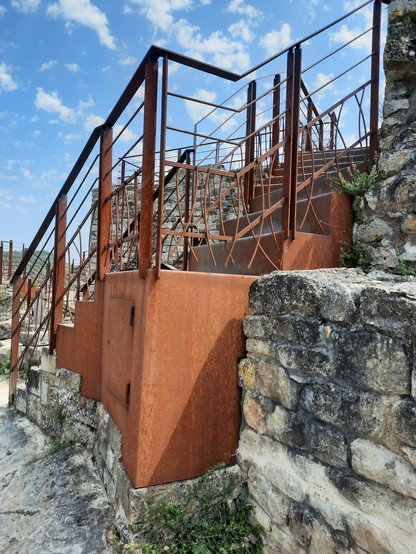 An iron staircase on top of a ruined chateau in a truly magnificent renovation of Penne