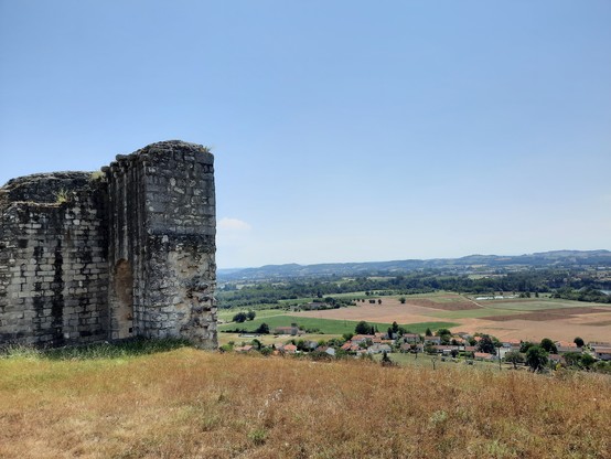 A stone castle fortification in ruins overlooking the valley below