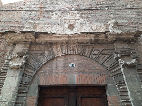 Eroded ornate masonry over a Renaissance-era exterior doir