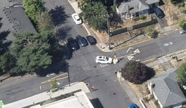 Aerial view of a car driver bumped into a cement cylinder in an intersection