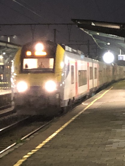 Train arriving at Schaarbeek station (Brussels). The morning sky is still dark.