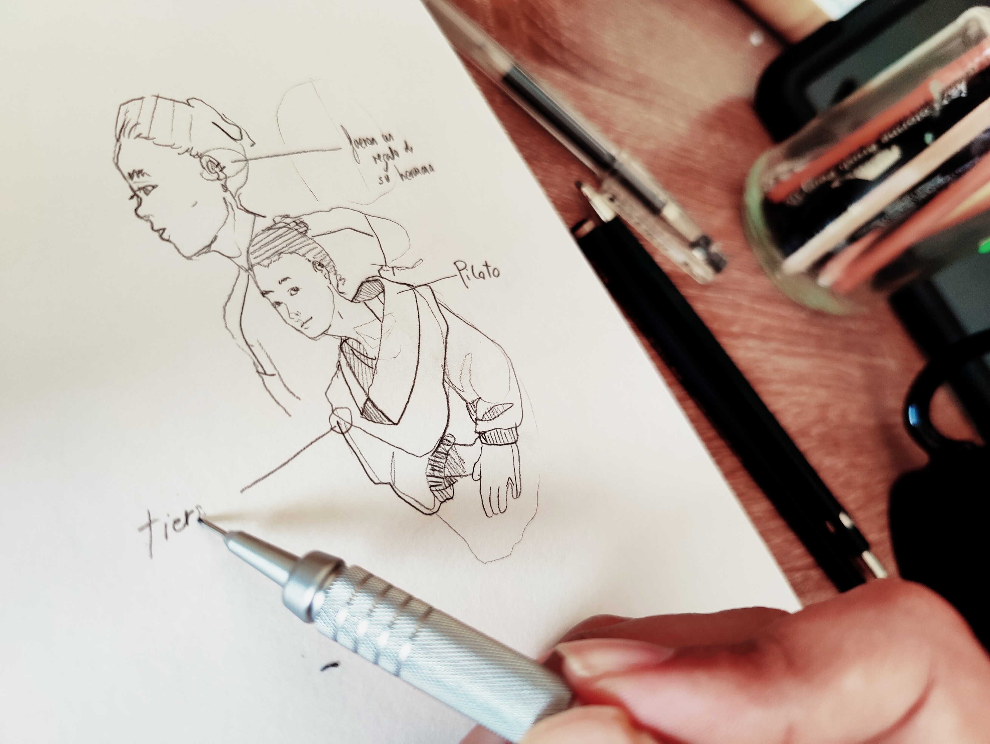 Mano dibujando y anotando sobre un boceto de una persona, a lápiz sobre papel