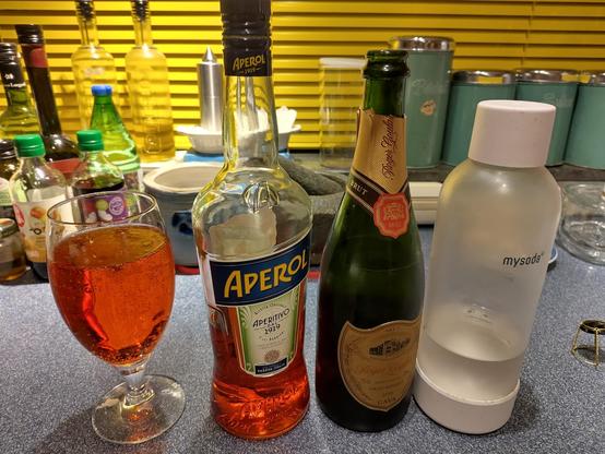 vlnr: glas Aperol Spritz, fles Aperol, fles Cava, fles bubbel water.