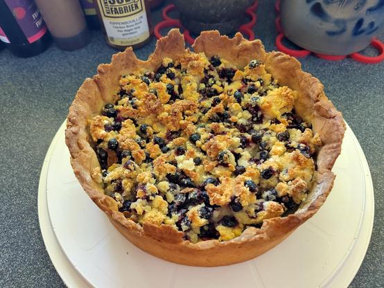 Zwarte bessen crumble taart op wit plateau
