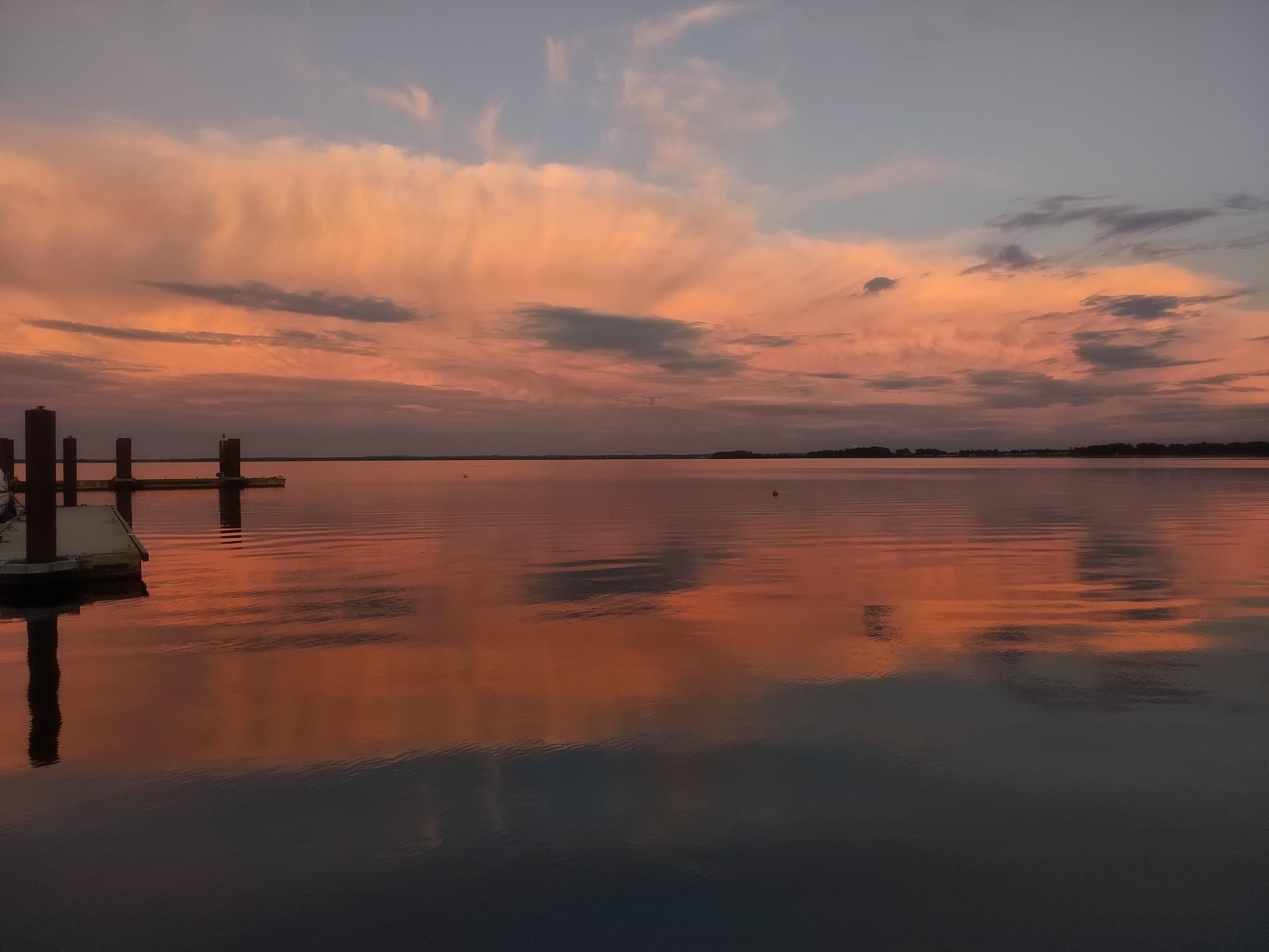 Orangerote Wolken über spiegelglatter see