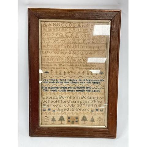 A hand embroidery sampler dated 1840 mounted in a wooden and glazed frame.