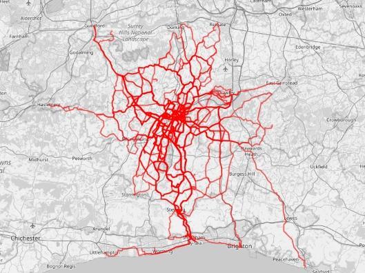 A grayscale OpenStreetMap of the south of England overlaid with a network map of cycling routes 