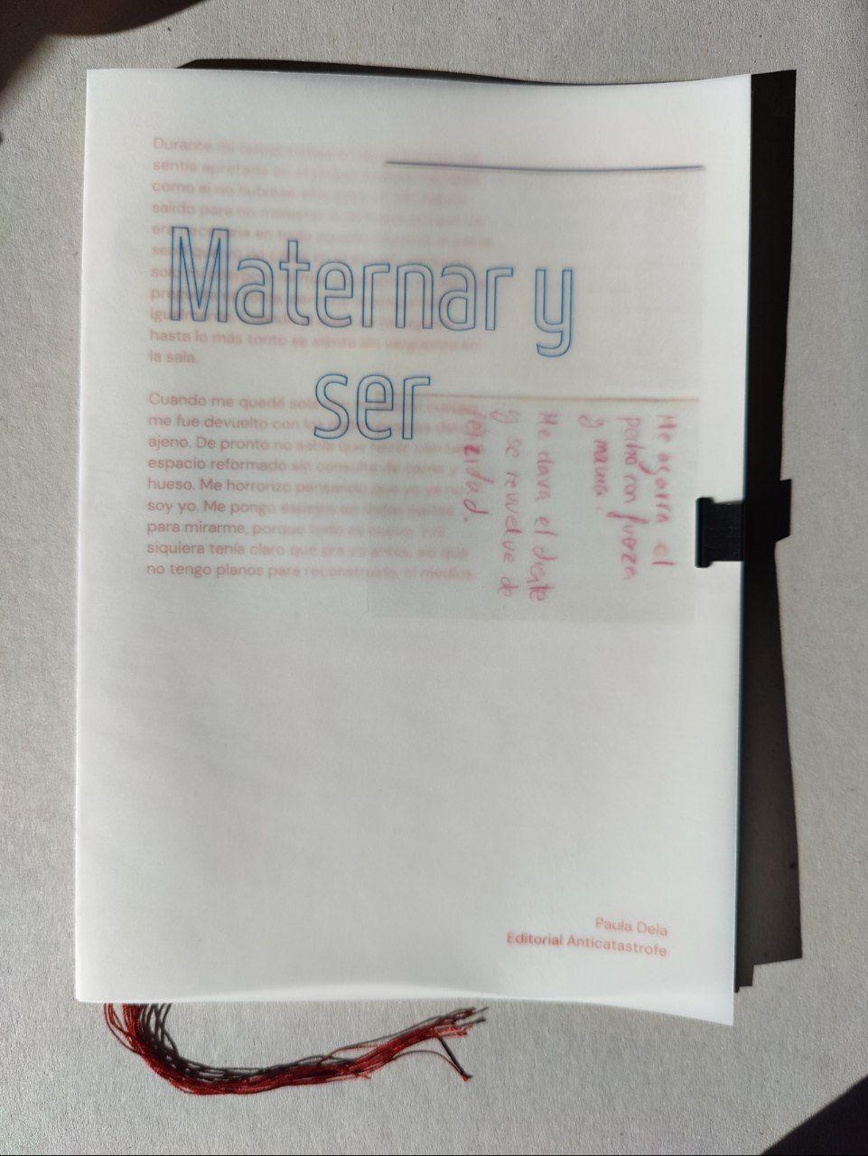 portada de un fanzine, transparente, titulado Maternar y ser, hay hilo rojo cayendo de entre las páginas