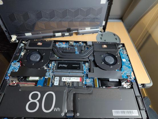 Open notebook with no SSDs on a tiny train table. There are crews in the cup holder.