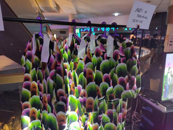 A rack of shirts with strange green and pink patterns.