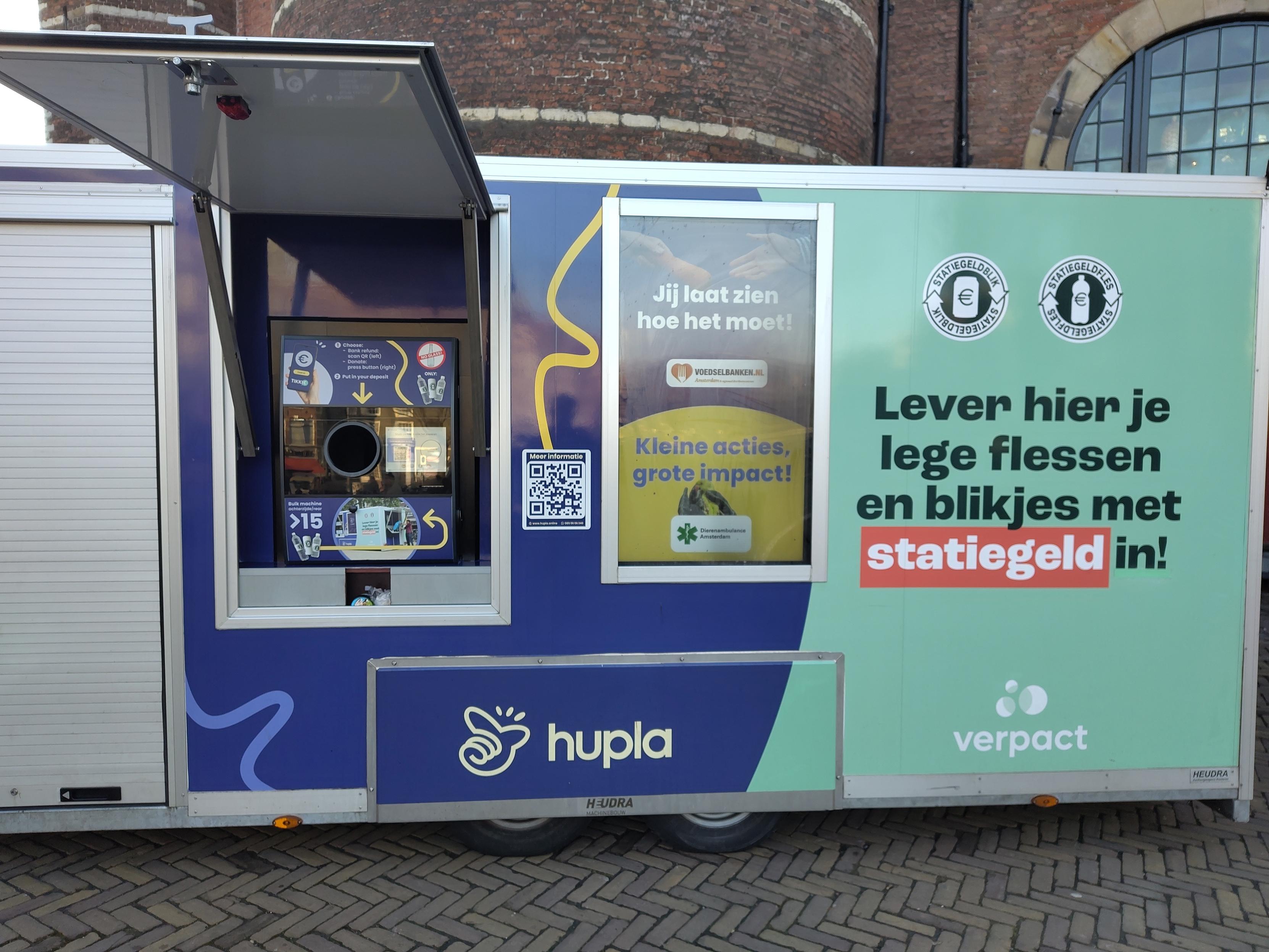 Un contenedor con huecos para tirar basura, código qr, etc ... En medio de una plaza importante de una ciudad europea.