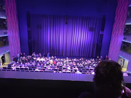 Grote zaal van de Almeerse Schouwburg. Voor aanvang, zaal nog half leeg, het doek is nog dicht.