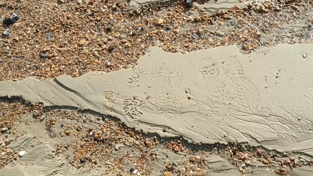 A trickle of sea water on a sandy beach