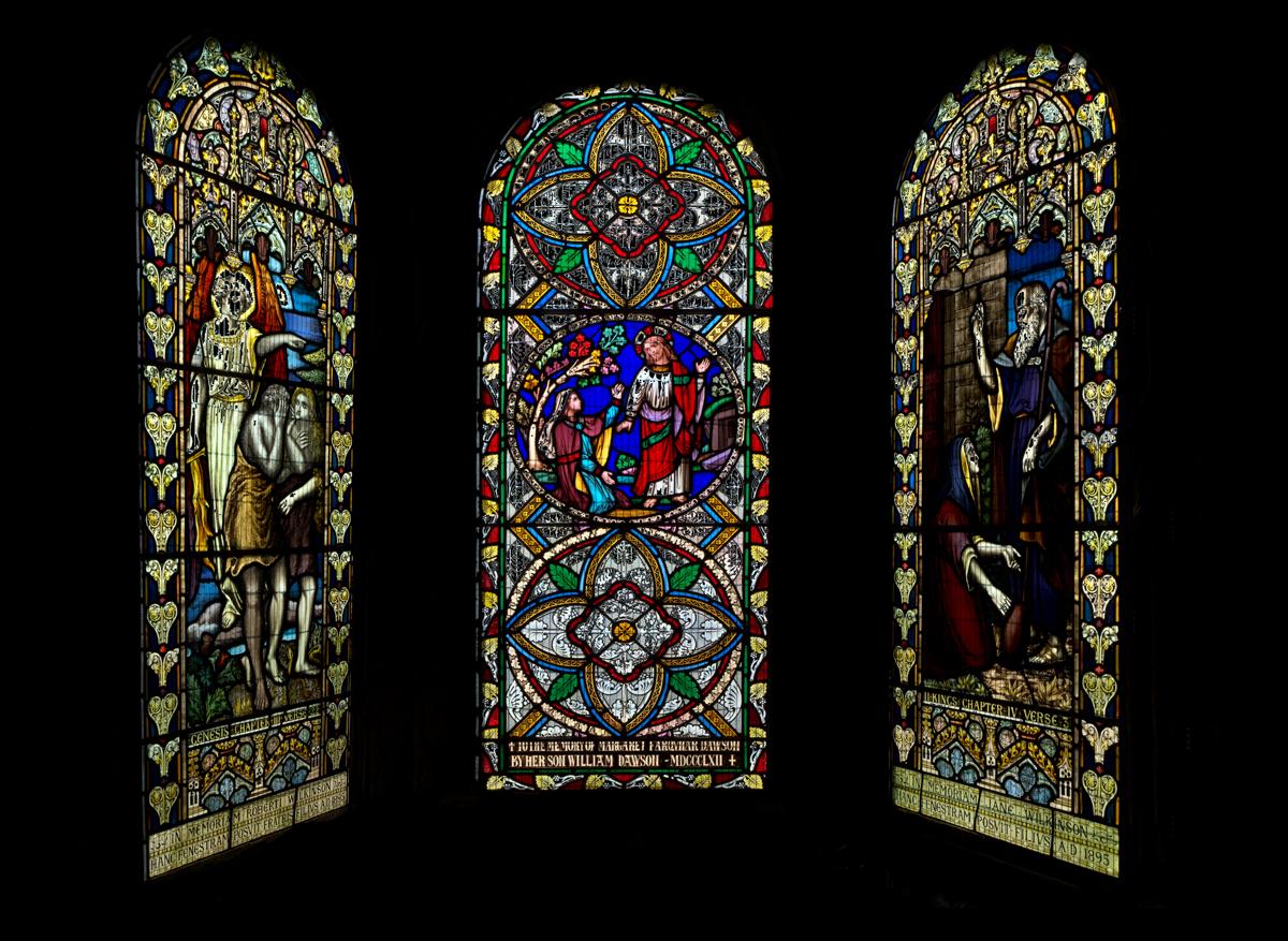 3 stained glass windows formed into a triptych in post processing, isolated against a black background.