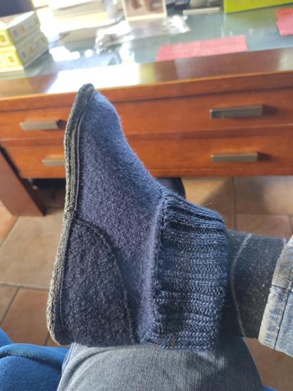 blauwgrijze vilten sloffen met een gebreide kraag rond de enkel.